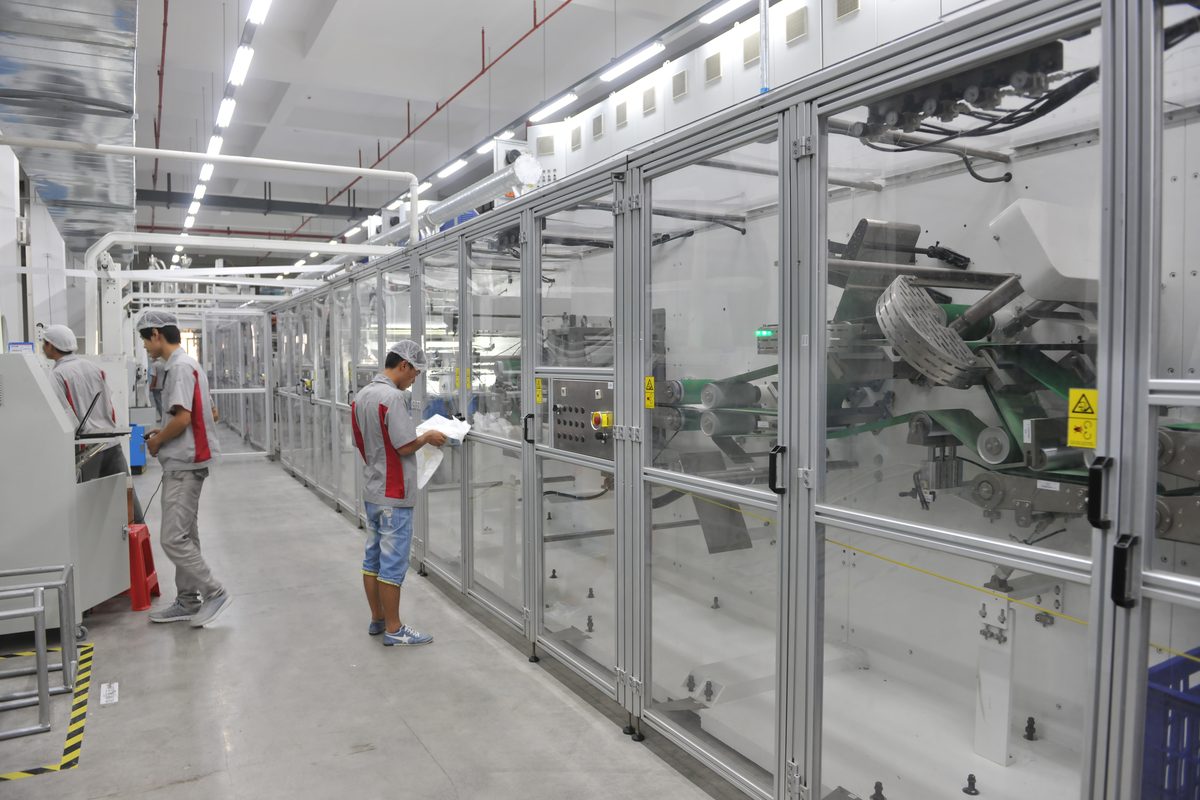 Glass-enclosed adult diaper production line — core forming, SAP injection, lamination stages